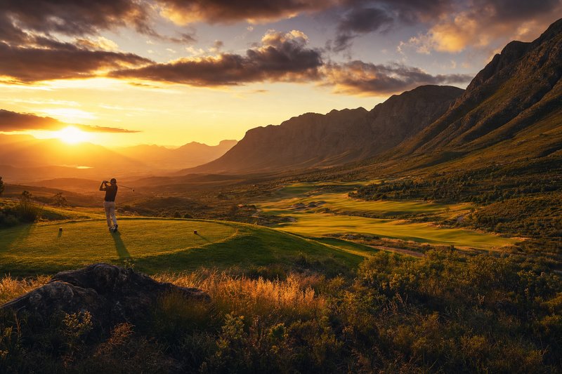 Golfplatz in Südafrika mit grünem Fairway und Bergkulisse